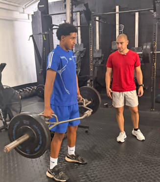 Coach Gam guiando un levantamiento de fuerza